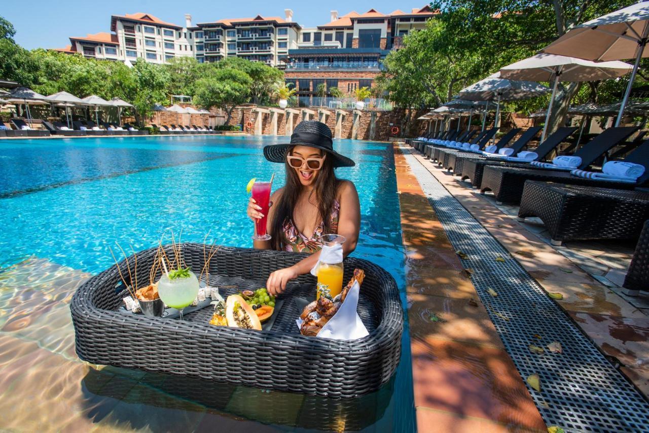 The Capital Zimbali Hotel Ballito Exterior photo A woman at a poolside lounge